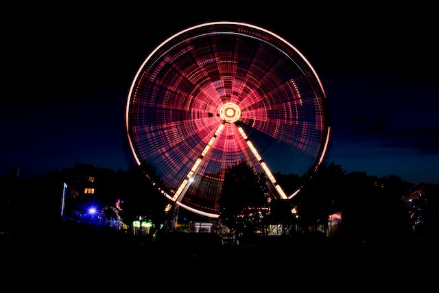 A ferris wheel lit up at night time
